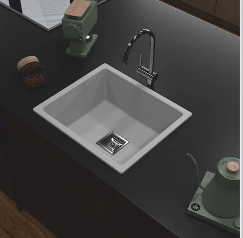 Gray kitchen sink with faucet on a dark countertop