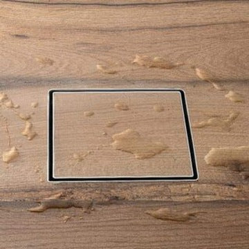 Rectangular cutout on a wooden surface with floor drainer