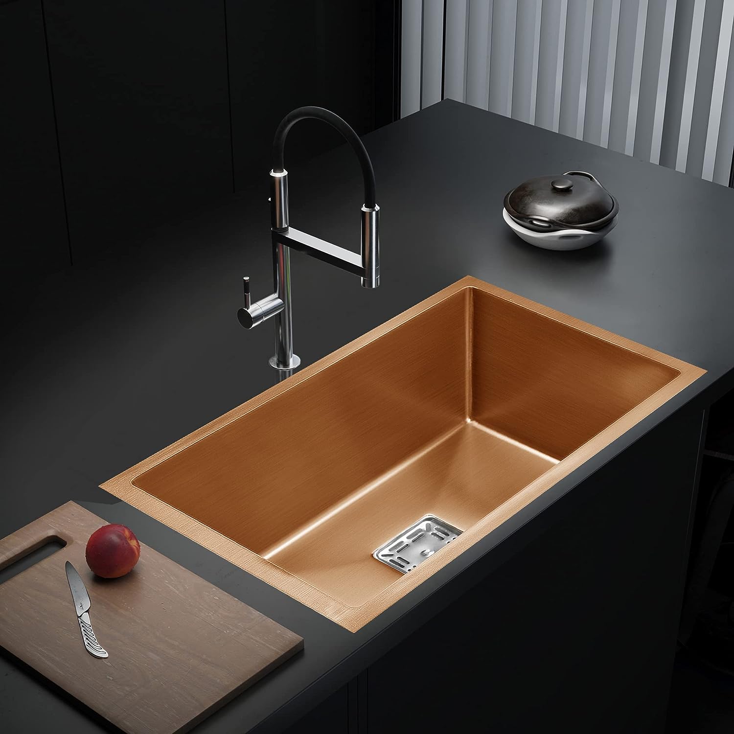 Copper kitchen sink with faucet on a dark countertop