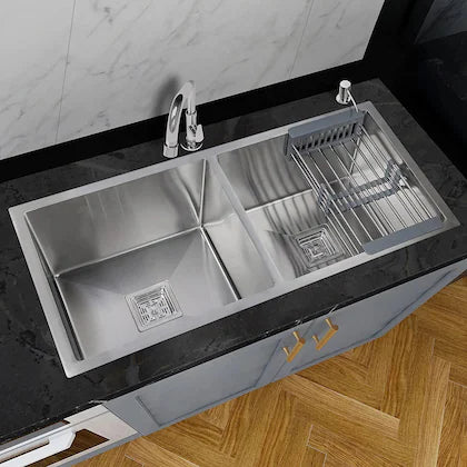 Stainless steel kitchen sink with faucet and dish rack on a countertop.